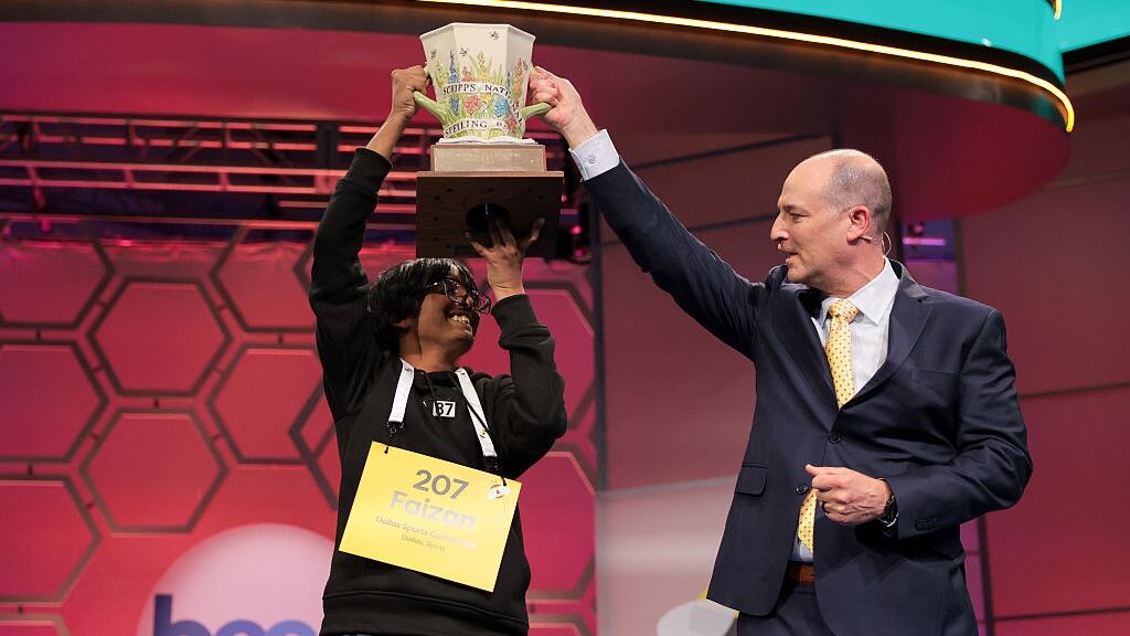 Faizan Zaki holds up the Scripps National Spelling Bee trophy.